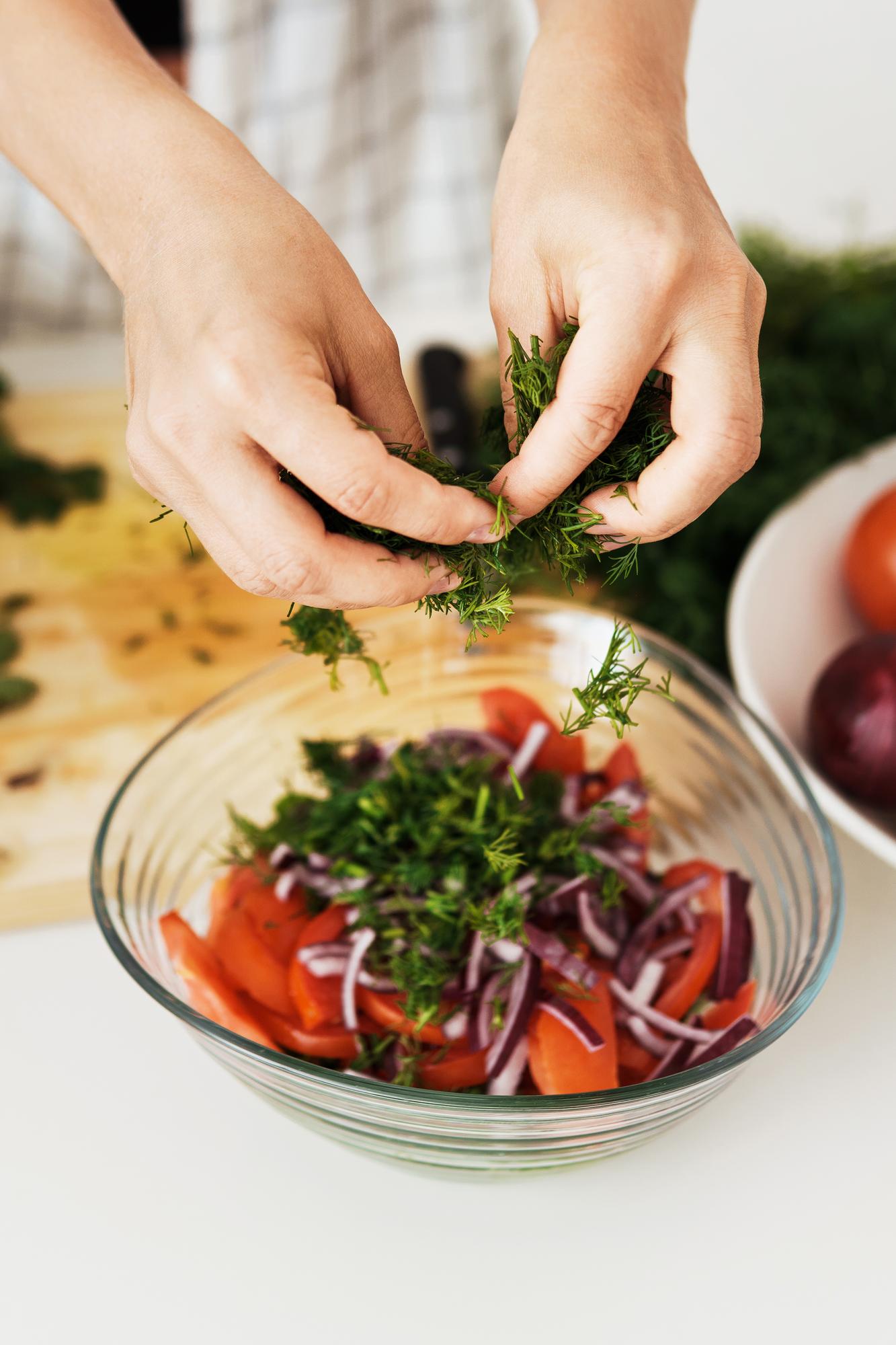 close-up of hand slicing herbs